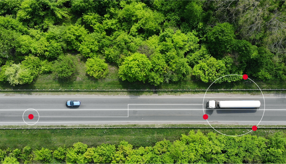 Caminhão em movimento em estrada com árvores no caminho.