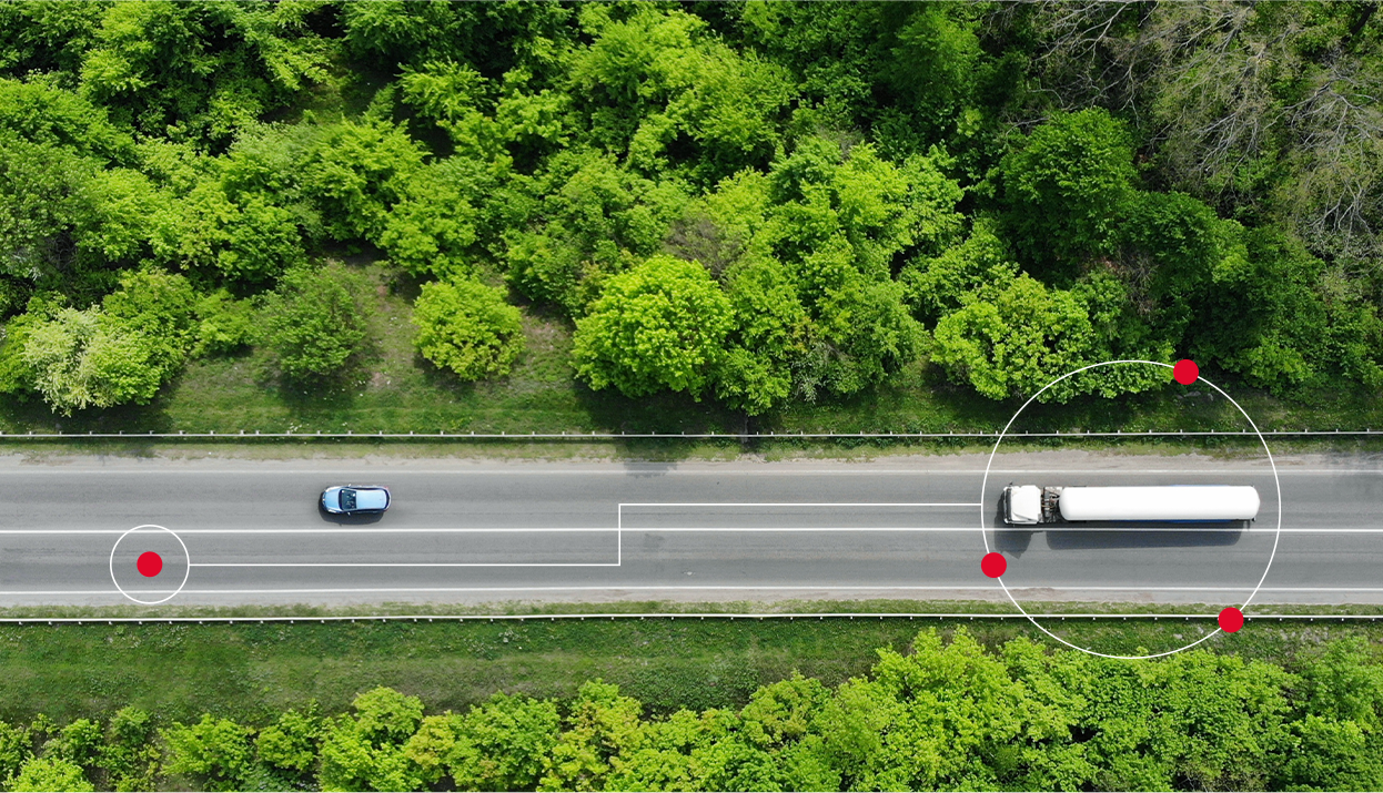 Caminhão em movimento em estrada com árvores no caminho.