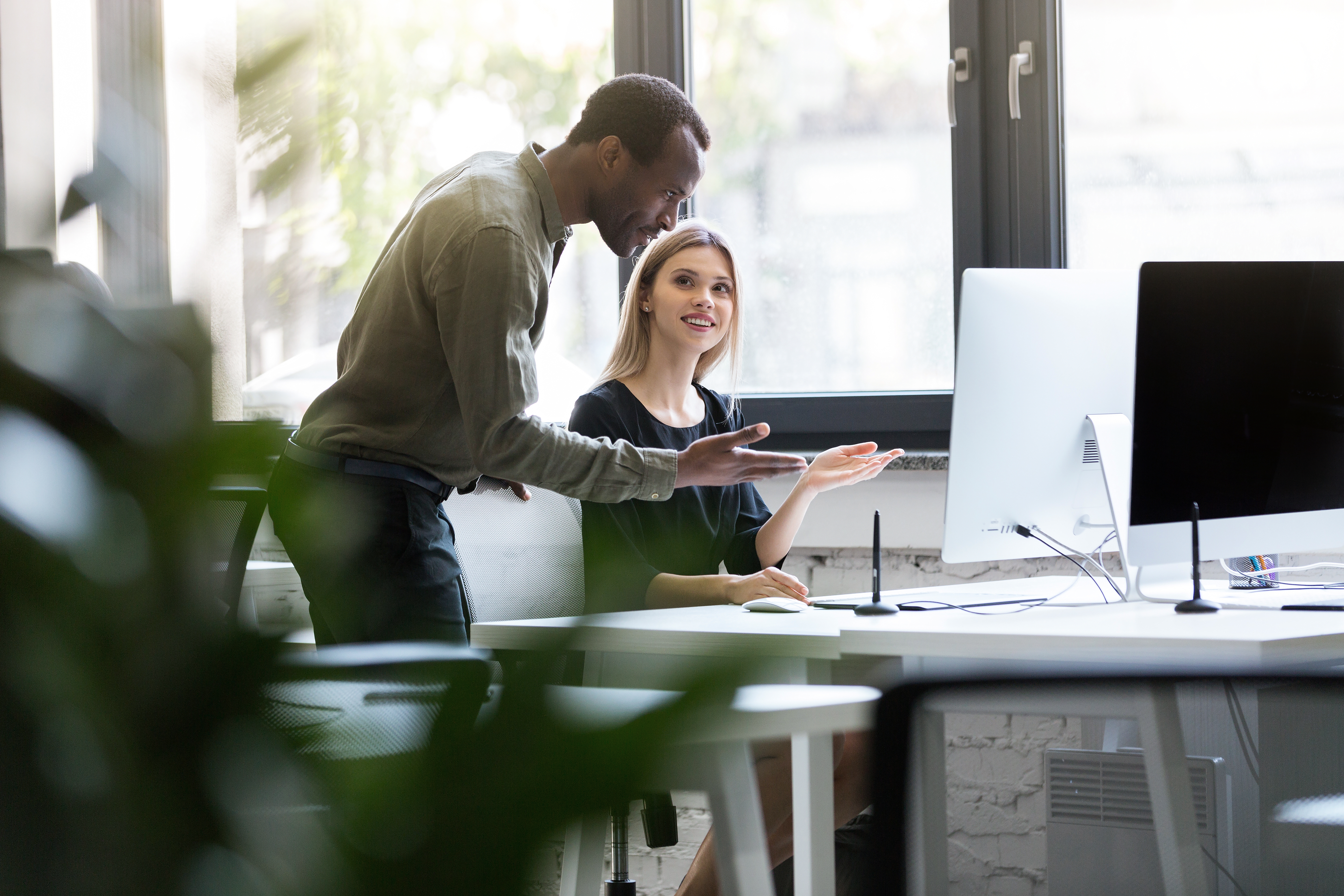 Duas pessoas apontando para tela do computador